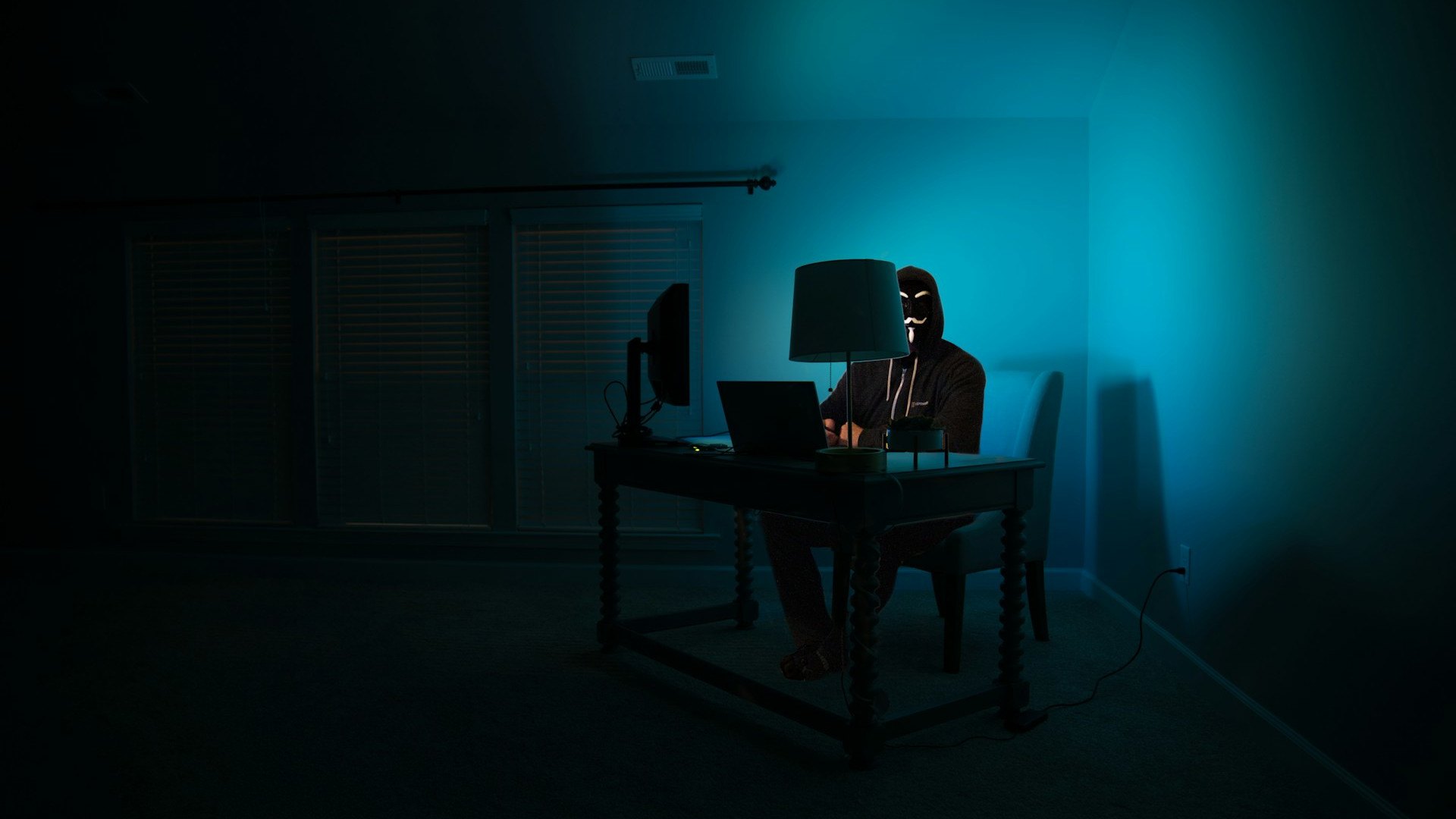 Hacker sitting in a dark room at a computer